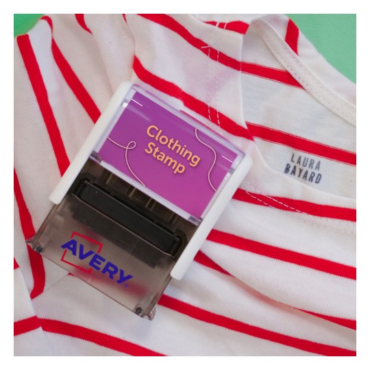 De afbeelding toont een kledingstempel van Avery op een gestreepte shirt. Het shirt heeft rode en witte strepen en een label met de naam 'Laura Bayard'.
