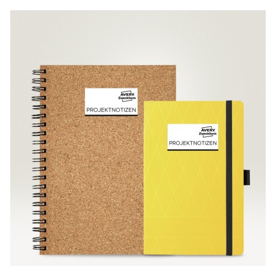 De afbeelding toont twee notitieboeken, één met een kurken kaft en de ander met een gele, gestructureerde kaft. Beide zijn gelabeld met 'PROJEKTNOTIZEN' en het logo van Avery Zweckform.