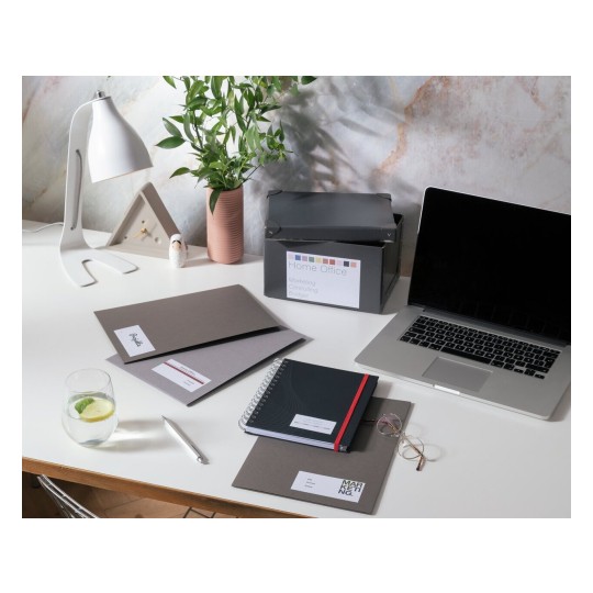 Op een bureau liggen verschillende kantoorbenodigdheden, waaronder een laptop, notitieboeken en hangmappen. Er is ook een plant en een glazen beker met limoen en citroen.