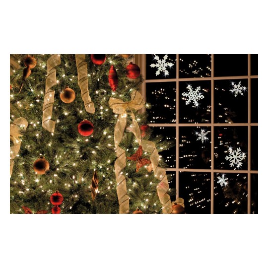 Deze afbeelding toont een prachtig versierde kerstboom met felgekleurde ornamenten en lichten. Achter de boom is een raam zichtbaar met sneeuwvlokken aan de binnenkant en een uitzicht op een mooie lichtshow buiten.