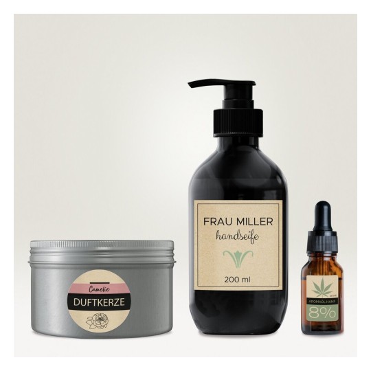 De afbeelding toont een collectie van schoonheidsproducten, waaronder een geurige kaars, een handzeep van Frau Miller in een zwarte fles, en een flesje met aromatische olie.