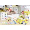 In de afbeelding zijn een paar beige schoenen zichtbaar die op een witte doos staan. Om hen heen zijn kleurcode-stickers en kortingspercentage-borden te zien, samen met verschillende getroffen doosjes voor etiket stickers.