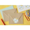 De afbeelding toont meerdere bruine enveloppen met een adressticker, een vel met gestreept papier, een potlood, en een bundel elastiekjes op een gele achtergrond.