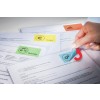 De afbeelding toont verschillende documenten met gekleurde labels zoals 'Budget', 'Meetings' en een pictogram van een tandwiel, waarbij iemand een sticker van een document afpelt.