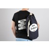 De afbeelding toont een man met een zwart T-shirt waarop 'TEAM marie' en 'EVG DE JULIEN' staat. Hij heeft een navy tas op zijn schouder met de opdruk 'EVG Julien'.